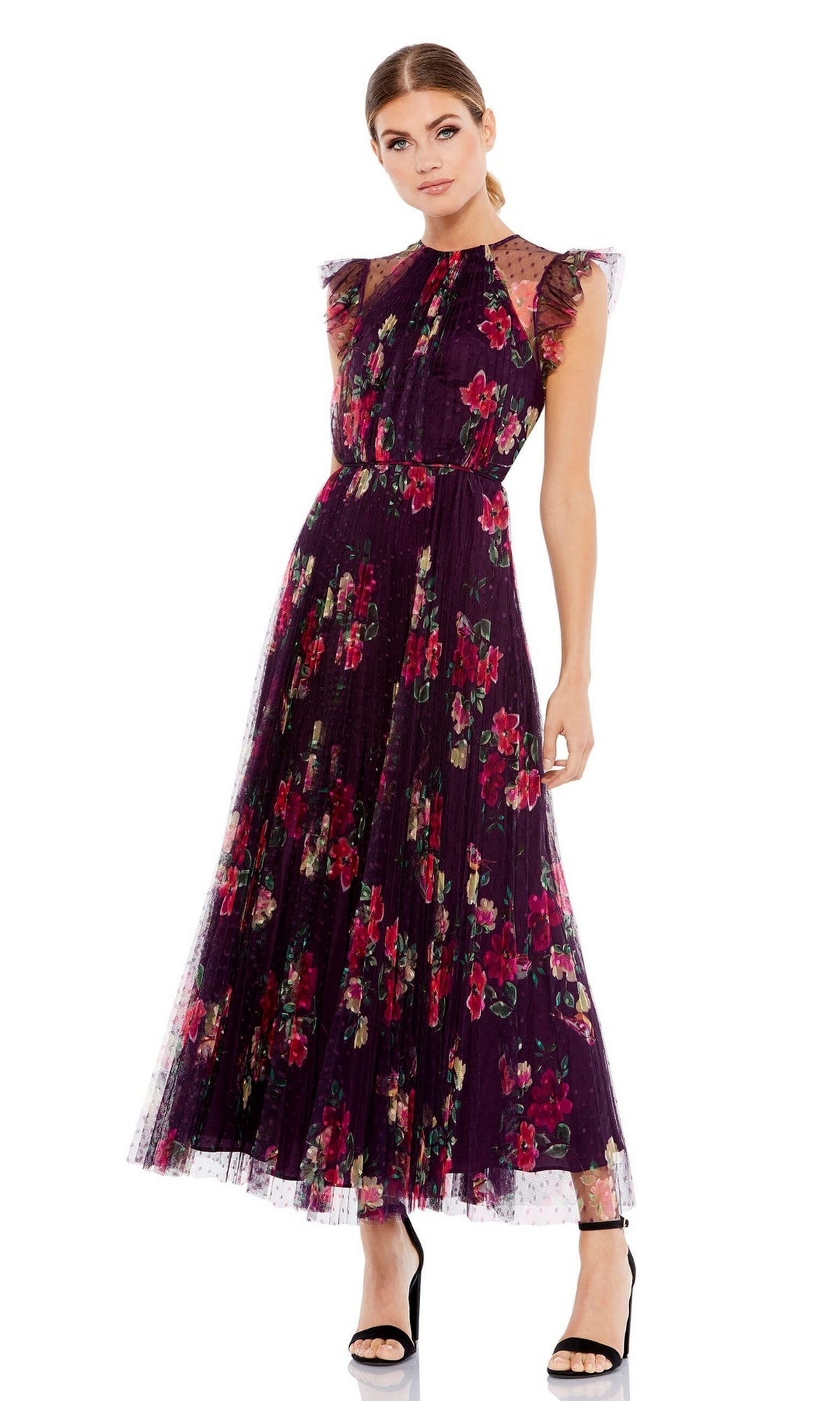 A woman wears the Mac Duggal 2143 Plum Print Midi Semi-Formal Dress with ruffled shoulders and black heels, standing against a white background.